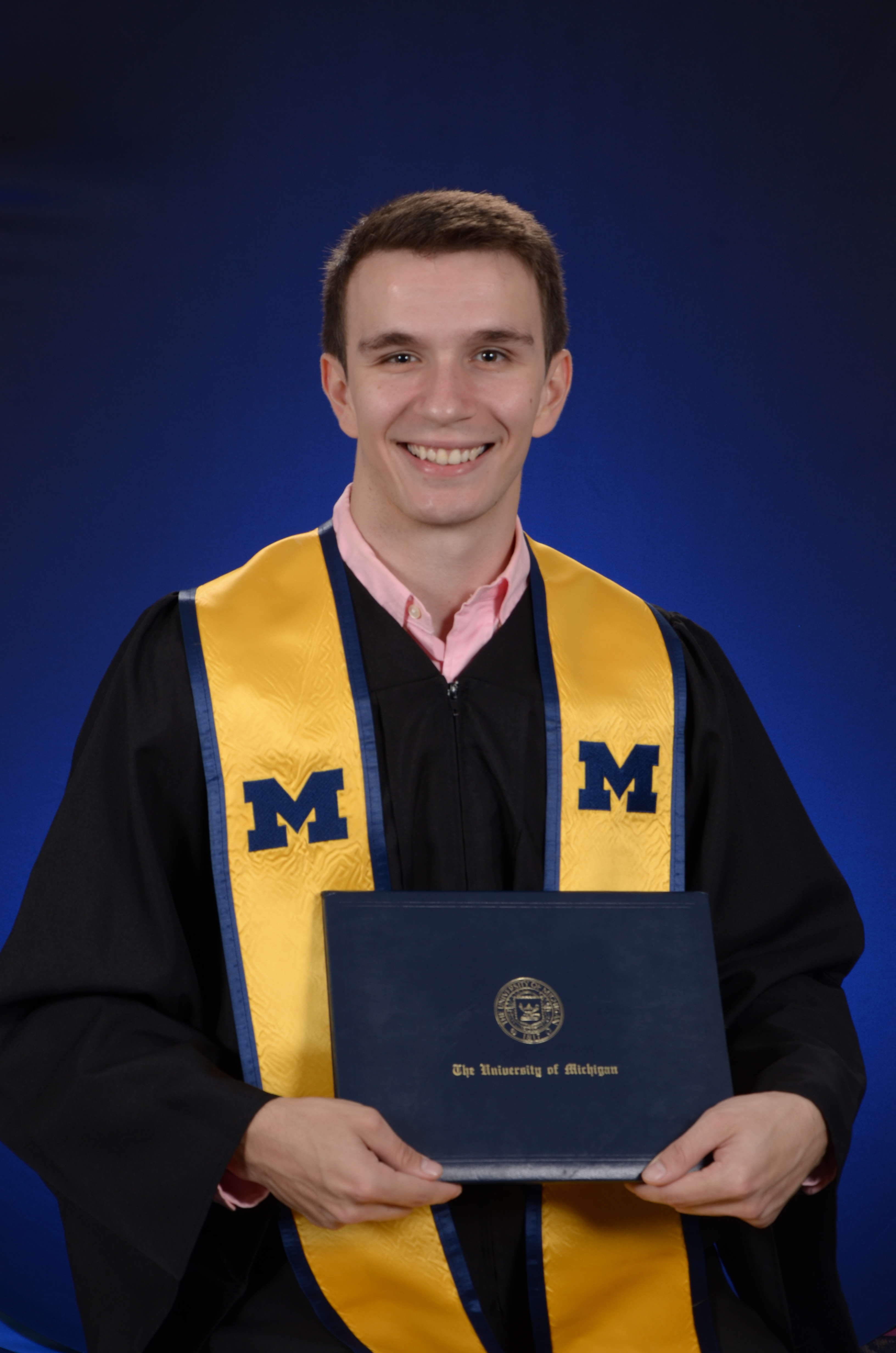shane in graduation outfit with diploma